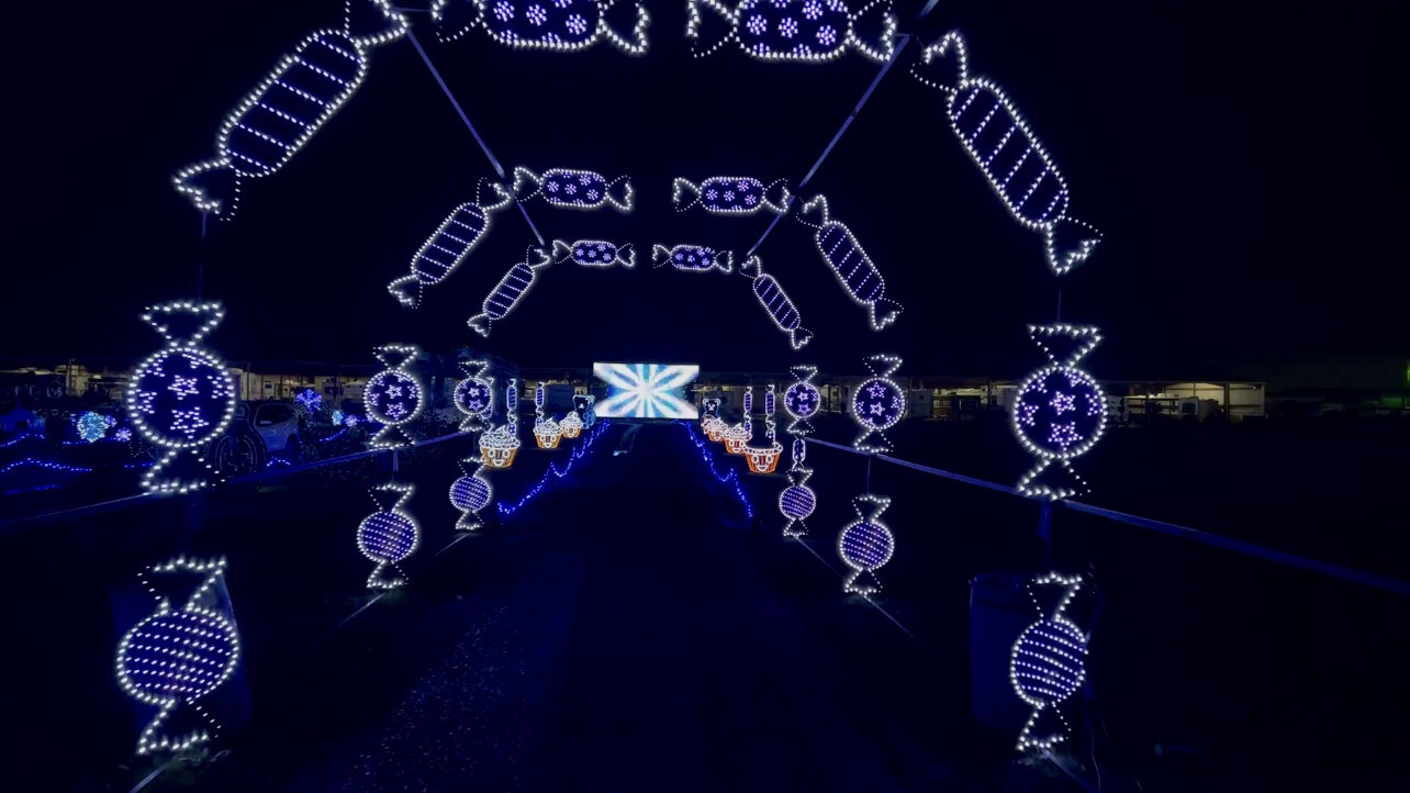 A drive-through tunnel of illuminated candy and sweets